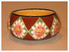 A Bali stoneware low bowl, decorated with white daisy flowers in geometric style on red brown background - first view.