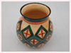 A Bali stoneware green vase, decorated with geometric design - four petals in bordered diamond shapes on peach bacgoround - third view.