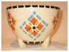 A Bali stoneware pot with feet, decorated with geometric pattern in pastel colours - first view.