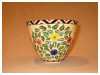 A Bali stoneware bowl, decorated with colourful daisies and leaves - third view.