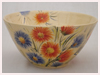 A Bali stoneware bowl decorated with blue and orange garden flowers - first view.