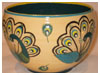 A Bali stoneware bowl, decorated with 4 colourful peacocks on cream background - third view.